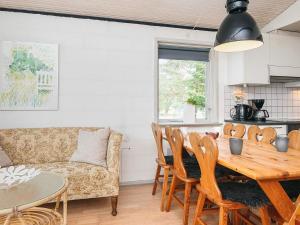 a living room with a table and a couch at 4 person holiday home in Blåvand in Blåvand +36 photos
