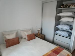 a bedroom with a bed with pillows and a closet at Casa da Canhota in São Mamede