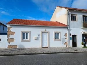 a white house with a red roof at Casa da Canhota in São Mamede