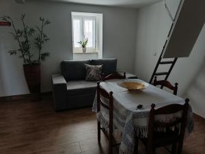 a living room with a table and a couch at Casa da Canhota in São Mamede