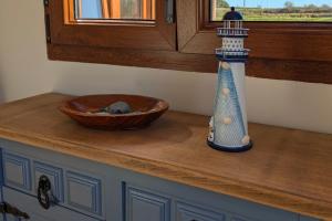 a counter top with a wooden bowl and a lighthouse toy at Casa de campo La Casuca Del Monje, San Vicente de la Barquera in La Acebosa