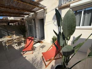 a patio with two chairs and a table and a plant at Cabanon des calanques aux Goudes in Marseille +21 photos