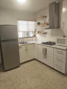 a white kitchen with a refrigerator and a microwave at Casa 25 Centrica con 3 recamaras in Hermosillo