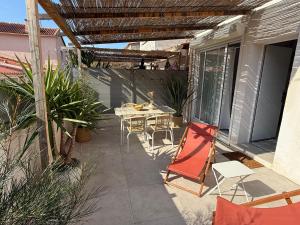 a patio with a table and chairs on it at Cabanon des calanques aux Goudes in Marseille