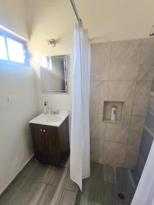 a bathroom with a sink and a shower with a mirror at Casa 25 Centrica con 3 recamaras in Hermosillo
