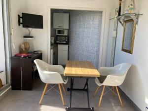 a small kitchen with a table and white chairs at Belle Suite Apt in Biarritz