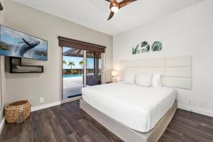 a white bedroom with a bed and a window at Ainamalu 9 in Waikoloa +50 photos