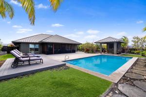 a villa with a swimming pool and a house at Ainamalu 9 in Waikoloa