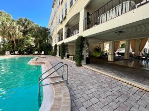 a swimming pool in front of a building at The Green Room - Pool View with Parking Spot at 1920s Historic Residence with 24x7 Reception Desk on Palm Beach Island in Palm Beach