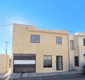 a building with two garage doors on the side of it at Casa 25 Centrica con 3 recamaras in Hermosillo