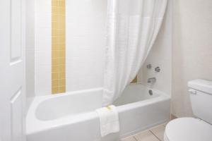 a bathroom with a white tub and a toilet at Days Inn by Wyndham Amherst OH - Near Cleveland Cedar Point & Lake Erie in Amherst +11 photos