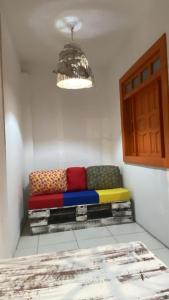 a colorful couch sitting in a corner of a room at Suítes Xicabacana in Mata de Sao Joao