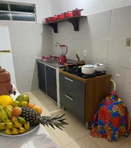 a kitchen with a bowl of fruit on a counter at Suítes Xicabacana in Mata de Sao Joao