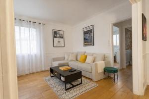 a white living room with a couch and a table at Une Maison en centre ville in Cholet