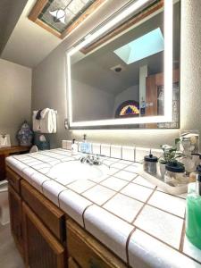 a bathroom with a sink and a large mirror at Forest Home with Deck, EV Station, King Beds in Cambria +35 photos
