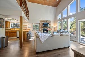 a living room with a couch and a kitchen at Forest Home with Deck, EV Station, King Beds in Cambria