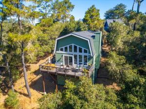 an aerial view of a tiny house in the woods at Forest Home with Deck, EV Station, King Beds in Cambria