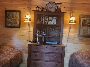 a bedroom with a dresser with a clock on it at Twin Bucks Cabin in Whiting