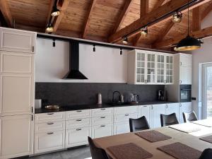 a kitchen with white cabinets and a table at Dom pod Aniołem in Sierakowice Prawe
