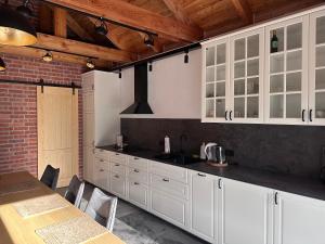 a kitchen with white cabinets and a brick wall at Dom pod Aniołem in Sierakowice Prawe +12 photos