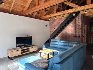 a living room with a blue couch and a tv at Dom pod Aniołem in Sierakowice Prawe