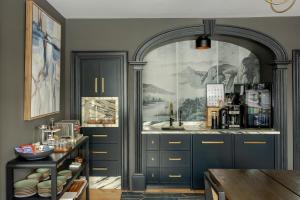 a kitchen with blue cabinets and an archway at Hattan House Boutique Hotel Bed & Breakfast in Niagara-on-the-Lake