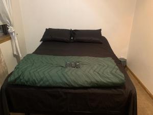 a bed with a green blanket and two shoes on it at The Upper Room in Milwaukee