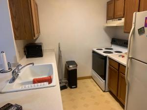 a kitchen with a sink and a white refrigerator at The Upper Room in Milwaukee