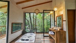 a bathroom with a tub and a large window at Pousada Irreplaceable in Visconde De Maua
