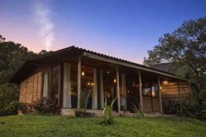 a small house with glass doors on a lawn at Pousada Irreplaceable in Visconde De Maua