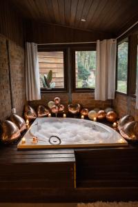 a large bath tub in a room with candles at Pousada Irreplaceable in Visconde De Maua