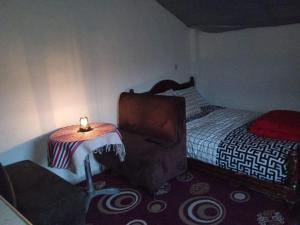 ein kleines Schlafzimmer mit einem Koffer neben einem Bett in der Unterkunft LuxeCabane in Kouf el Fouki