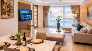a living room with a dining table and a living room with a couch at Capitоl Suites & Apartments in Skopje