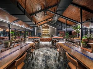 a restaurant with wooden tables and chairs and a bar at Hotel Gosford in Gosford