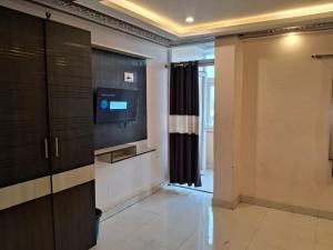 a living room with a television and a door at BN Hotel in kolkata