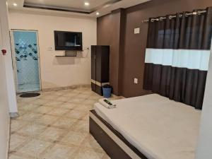 a bedroom with a bed and a flat screen tv at BN Hotel in kolkata