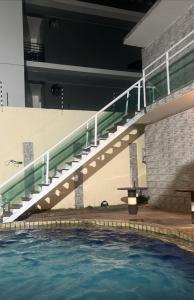 a stairway over a swimming pool in a building at Pousada Camboinha in Cabedelo