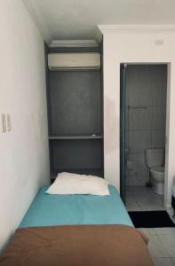 a bedroom with a bed and a bathroom with a toilet at Pousada Camboinha in Cabedelo