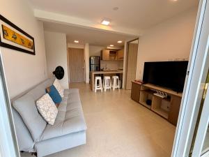 a living room with a couch and a flat screen tv at Apartamento en Villeta in Villeta