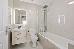 a white bathroom with a toilet and a tub and a sink at Dublin Premier Oasis in Ráth Cúil +40 photos