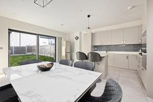 a kitchen with a white table and chairs and a counter at Dublin Premier Oasis in Ráth Cúil