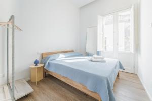 a white bedroom with a bed and a window at Dimora del Polpo - Centro Storico in Trapani
