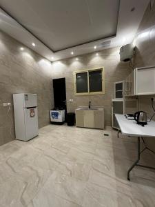 a large room with a kitchen with a refrigerator at شقق وغرف الرصف in Hail