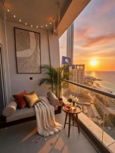 a balcony with a couch and a view of the ocean at برج داماك الكورنيش - Damac Al-Corniche Tower in Jeddah