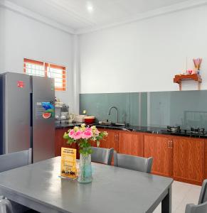 a kitchen with a table with a vase of flowers on it at HOMESTAY- Hưng Thịnh in Vạn Ninh