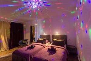 two beds in a room with a ceiling with lights at Apinelo Rooms in Split