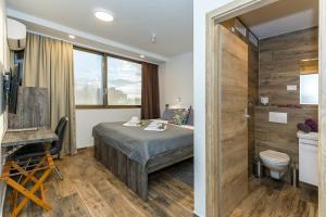 a hotel room with a bed and a bathroom at Apinelo Rooms in Split