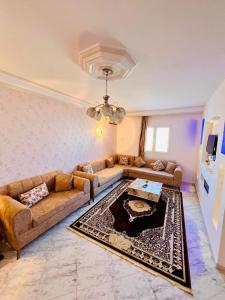 a living room with two couches and a table at Villa Joury in Al Maqārisah