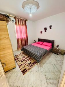 a bedroom with a bed with pink pillows on it at Villa Joury in Al Maqārisah +32 photos