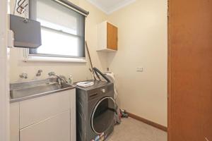a kitchen with a washing machine next to a sink at Jack & Bias Cottage in Warrnambool